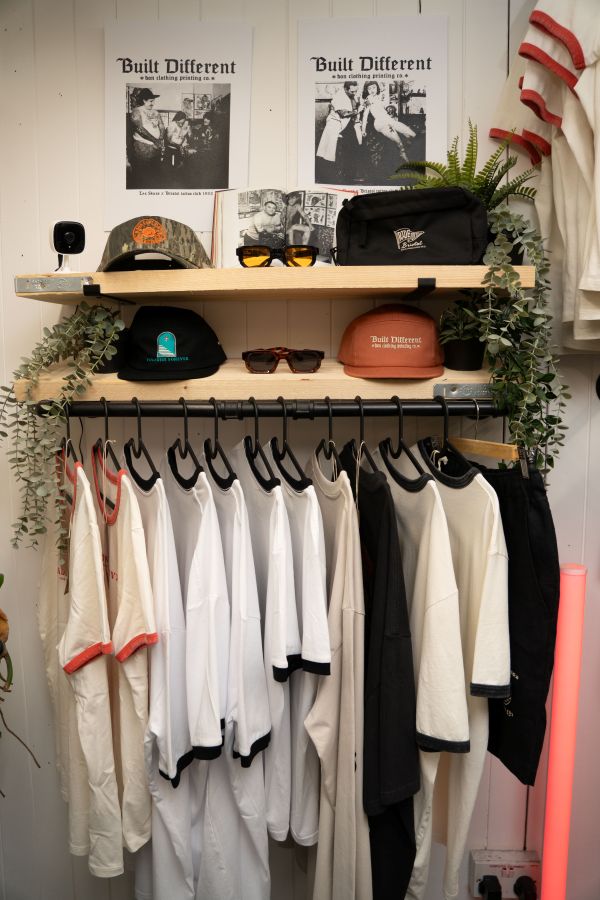 Bon clothing products including t shirts on a rail, hats and sunglasses