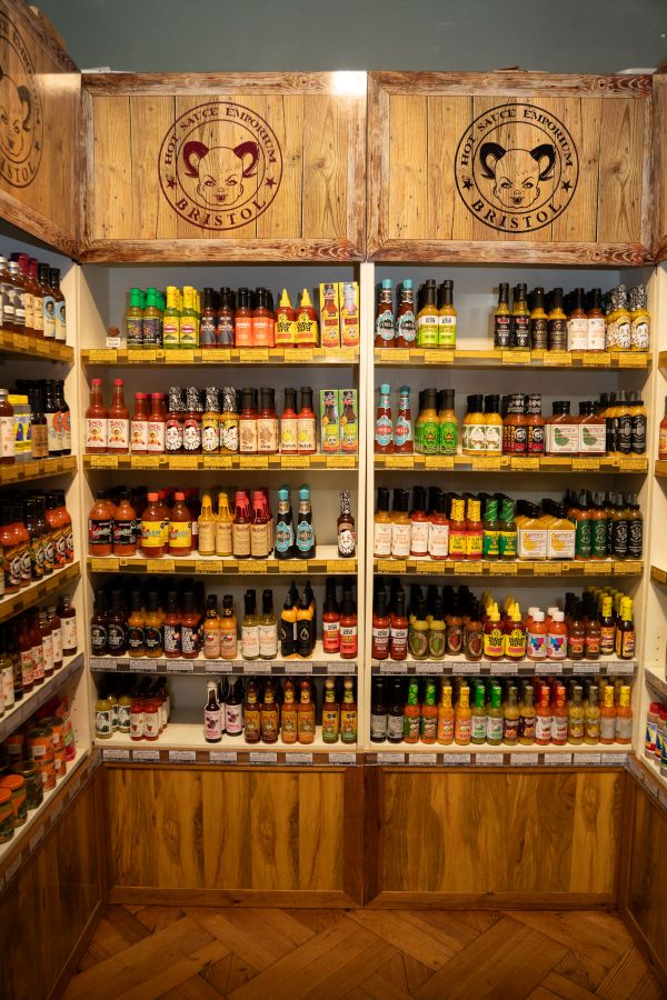 different jars and bottles of hot sauce on shelves