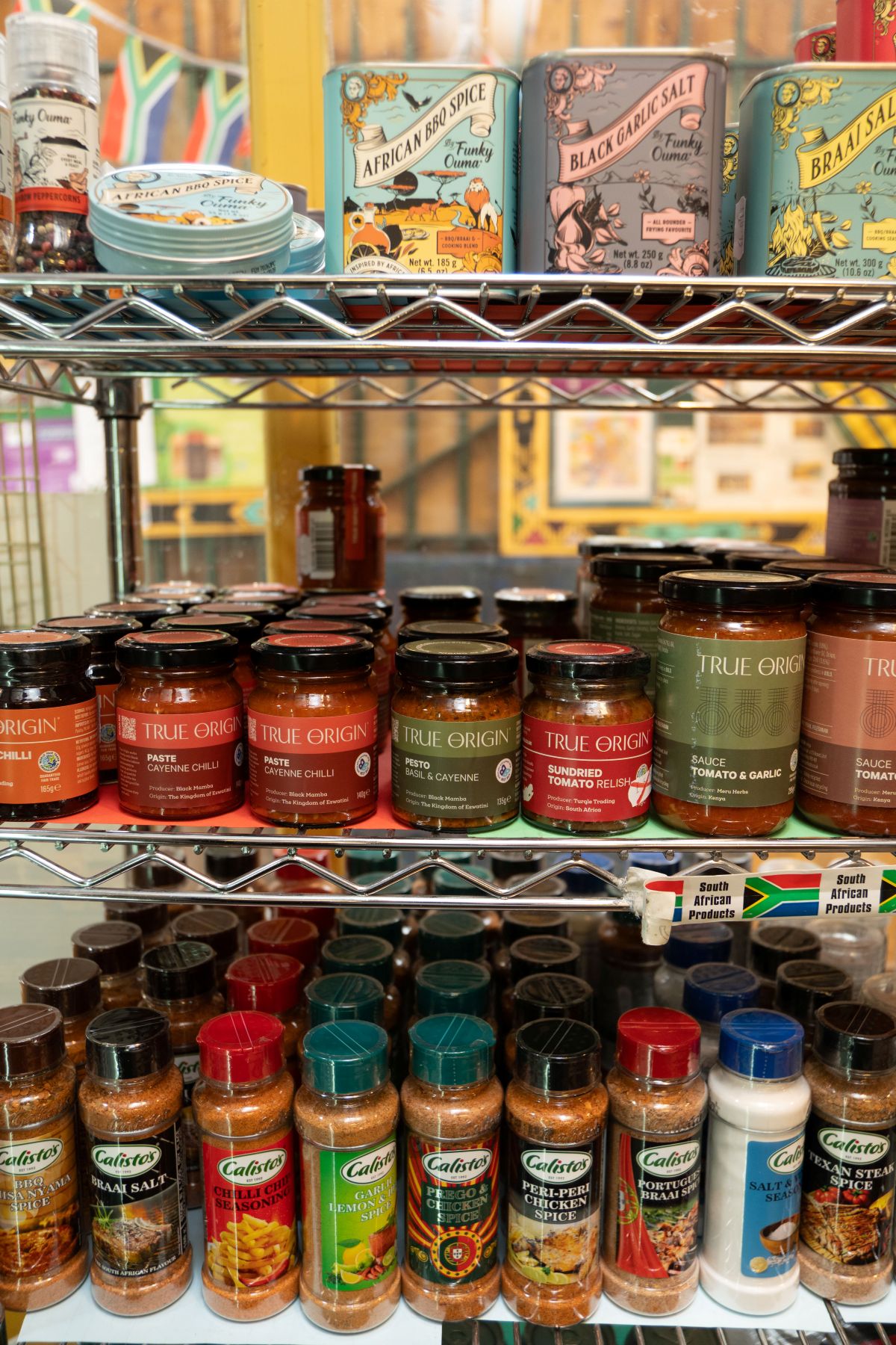 Jars of sauce, different spices and other related items on shelves in a shop