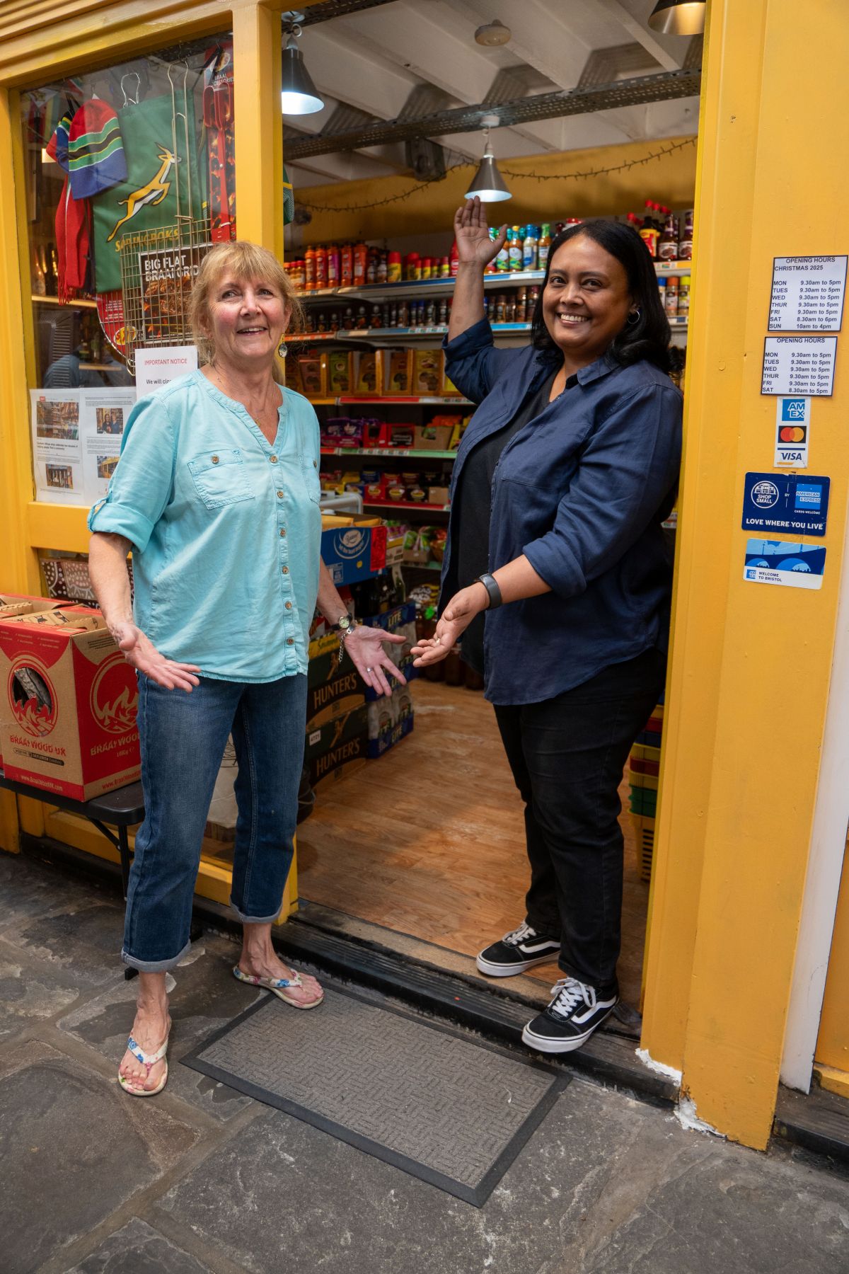 Two women standing outside their shop smiling