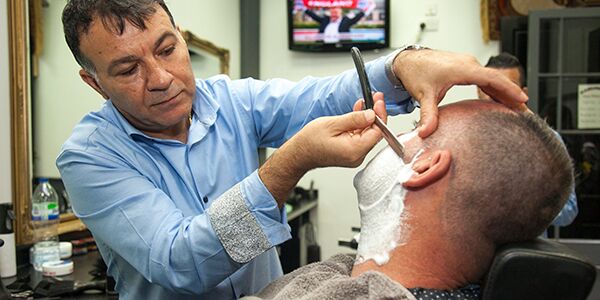 A man shaving another man's face