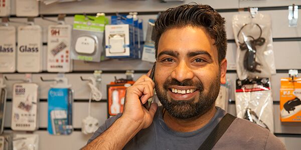A man smiling with a phone to his ear