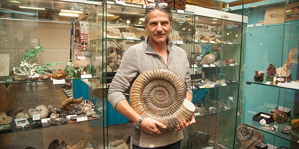 A man holding up a large fossil