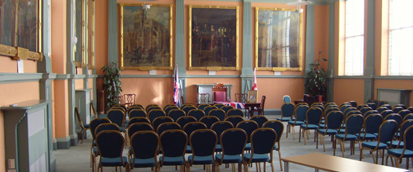 a heritage room with paintings on the walls and rows of chairs