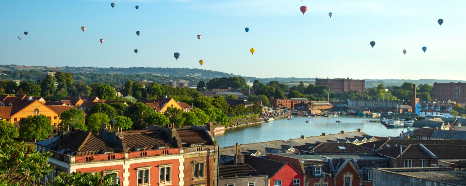 View over the river of the hot air balloons from the Bristol Balloon Fiesta in 2025 with houses in the foreground