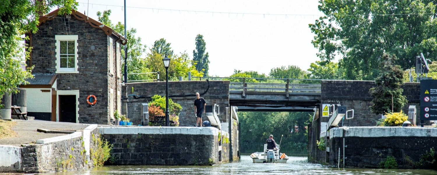 A person in a small boat passing through Netham Lock