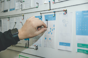 a hand pinning a note on a board by other notes